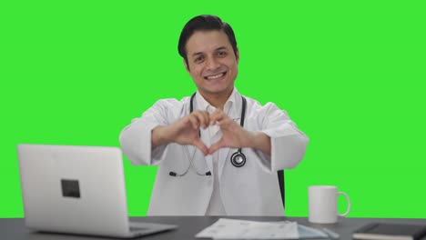 Glücklicher-Indischer-Arzt,-Der-Einen-Grünen-Bildschirm-Mit-Herzzeichen-Zeigt