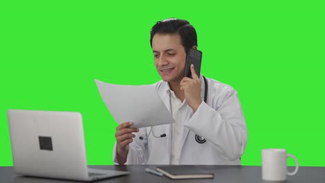 Happy-Indian-doctor-delivering-good-news-on-phone-Green-screen