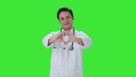 Glücklicher-Indischer-Arzt,-Der-Einen-Grünen-Bildschirm-Mit-Herzzeichen-Zeigt