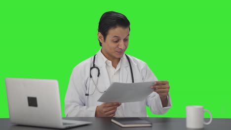 Glücklicher-Indischer-Arzt,-Der-Medizinische-Berichte-Auf-Grünem-Bildschirm-überprüft
