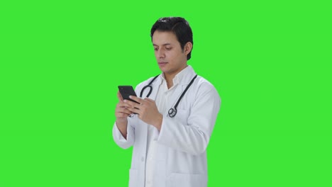 Indischer-Arzt-Chattet-Auf-Dem-Grünen-Bildschirm-Des-Telefons