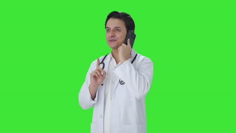 Fröhlicher-Indischer-Arzt,-Der-Auf-Dem-Grünen-Bildschirm-Des-Telefons-Spricht