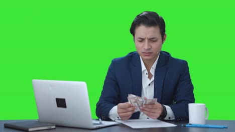 Confused-Indian-businessman-counting-money-Green-screen