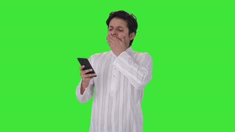 Tired-Indian-man-scrolling-phone-Green-screen