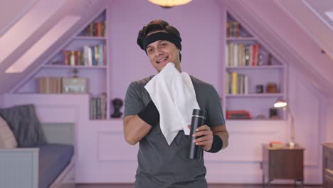 Happy-Indian-man-wiping-sweat-and-drinking-water-after-exercise