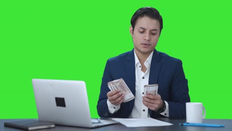 Indian-businessman-counting-money-in-office-Green-screen