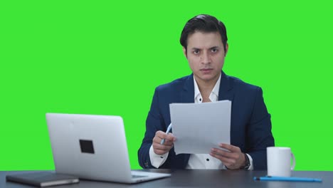 Angry-Indian-manager-reading-and-signing-reports-Green-screen