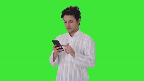 Ernsthafter-Indischer-Mann,-Der-Auf-Dem-Grünen-Bildschirm-Des-Telefons-Scrollt