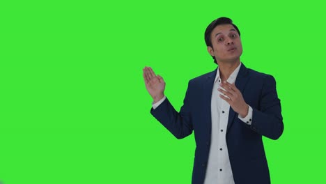 Happy-Indian-journalist-pointing-to-Copy-Space-and-talking-Green-screen