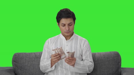 Serious-Indian-man-counting-money-Green-screen