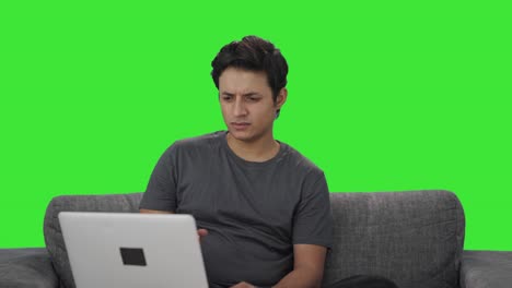Confused-Indian-man-working-on-laptop-Green-screen