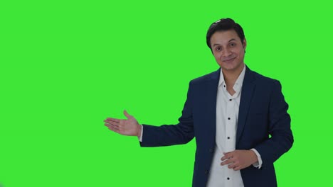 Happy-Indian-journalist-pointing-Copy-Space,-showing-victory-sign-Green-screen