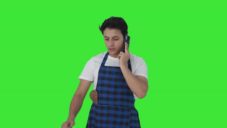 Indian-cook-making-food-while-talking-on-phone-Green-screen