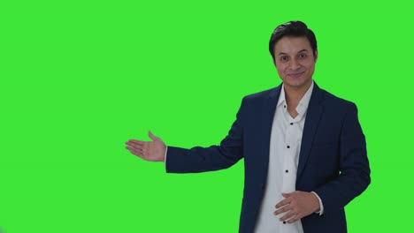 Happy-Indian-journalist-pointing-to-Copy-Space-Green-screen