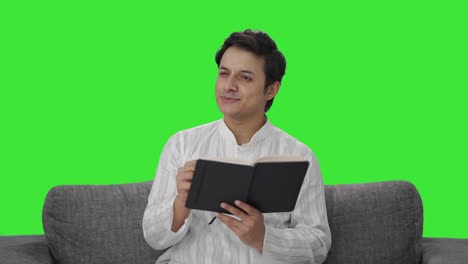 Happy-Indian-man-writing-a-diary-Green-screen