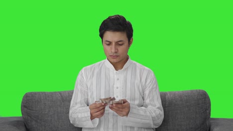 Sad-Indian-man-counting-money-Green-screen