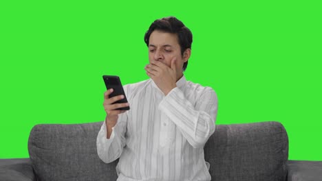 Tired-Indian-man-scrolling-phone-Green-screen
