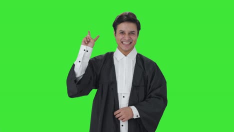 Fröhlicher-Indischer-Anwalt-Zeigt-Siegeszeichen-Auf-Grünem-Bildschirm