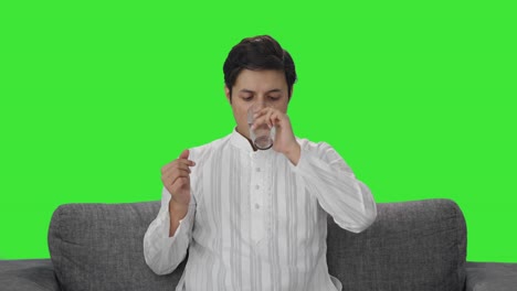 Sick-Indian-man-taking-medicine-Green-screen