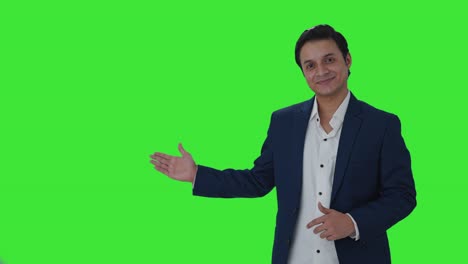 Happy-Indian-journalist-pointing-Copy-Space-and-showing-thumbs-up-Green-screen