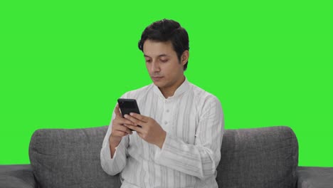 Indischer-Mann-Chattet-Auf-Dem-Grünen-Bildschirm-Des-Telefons