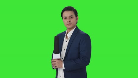 Portrait-of-Confident-Indian-reporter-standing-crossed-hands-Green-screen