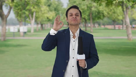 Cheerful-Indian-reporter-showing-okay-sign