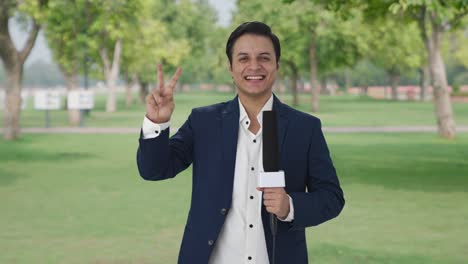 Cheerful-Indian-reporter-showing-victory-sign