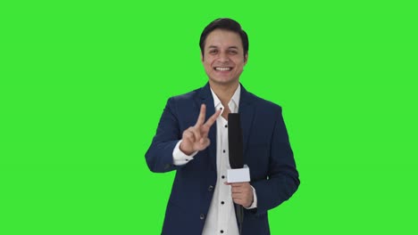 Happy-Indian-reporter-showing-victory-sign-Green-screen