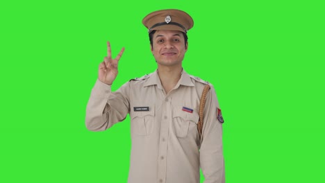 Fröhlicher-Indischer-Polizist-Zeigt-Siegeszeichen-Auf-Grünem-Bildschirm