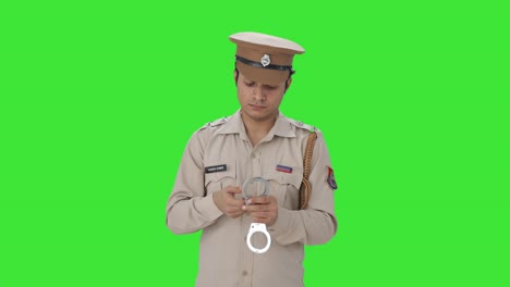Indian-police-officer-checking-handcuffs-Green-screen