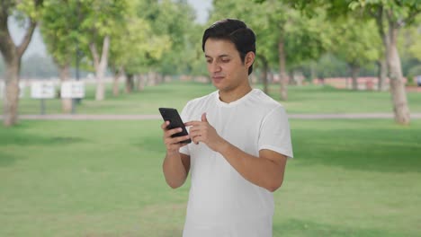 Indian-man-scrolling-through-phone