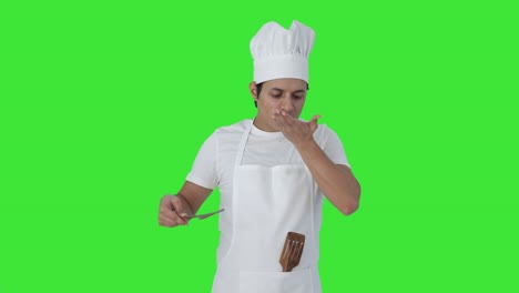 Happy-Indian-professional-chef-tasting-food-and-showing-okay-sign-Green-screen