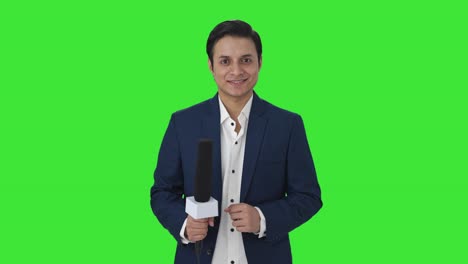 Glücklicher-Indischer-Reporter,-Der-Zum-Grünen-Bildschirm-Der-Kamera-Lächelt