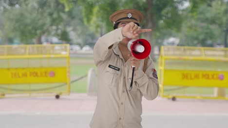 Oficial-De-Policía-Indio-Controlando-Cuervos-Usando-Megáfono