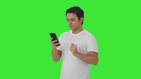 Happy-Indian-man-scrolling-through-phone-Green-screen