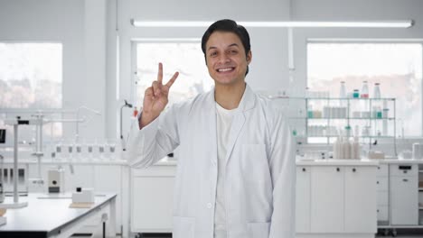 Happy-Indian-scientist-showing-victory-sign