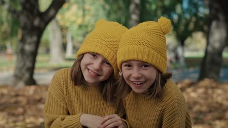 Portrait-of-child-siblings-standing-in-the-woods-and-wearing-yellow-hats.