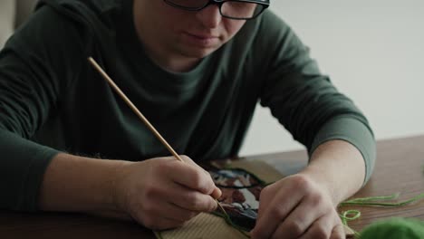 Close-up-of-adult-caucasian-man-with-down-syndrome-making-a-craft.