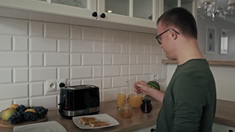 Adult-caucasian-man-with-down-syndrome-preparing-and-passing-breakfast-to-his-mom
