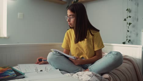 Kaukasisches-Teenager-Mädchen-Sitzt-Auf-Dem-Bett-Und-Macht-Hausaufgaben