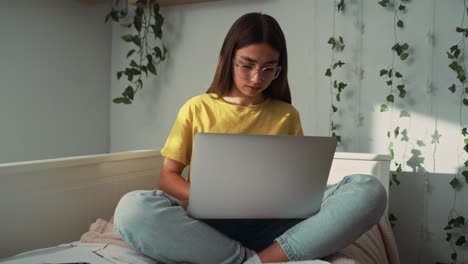 Kaukasisches-Teenager-Mädchen-Sitzt-Auf-Dem-Bett-Und-Lernt-Vom-Laptop