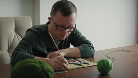 Adult-caucasian-man-with-down-syndrome-making-a-craft.