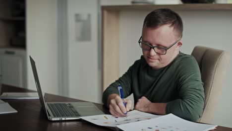 Man-with-down-syndrome-learning-at-home-using-laptop.