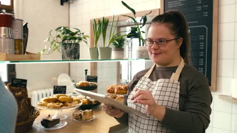 Down-syndrome-girl-serving-meal-for-a-client-at-the-table