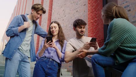 Group-of-students-browsing-phone-next-to-to-university-campus