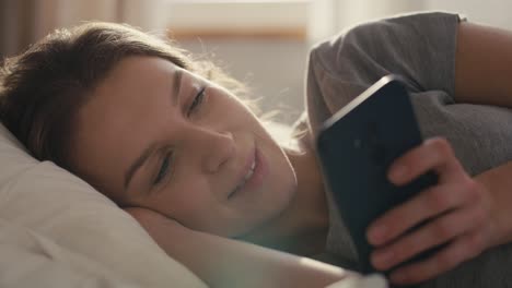 Caucasian-woman-lying-in-bed-at-morning-and-using-mobile-phone.