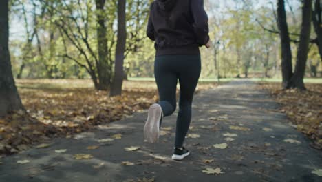 Handheld-of-low-section-of-woman's-legs-jogging-at-the-park