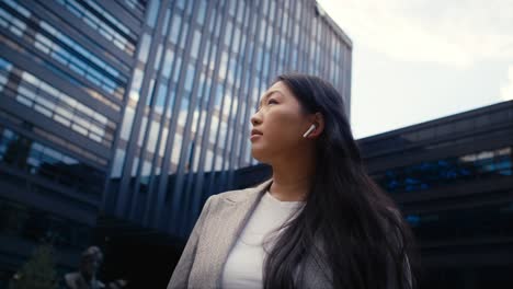 Business-Chinese-woman-standing-on-the-street-in-the-city-and-looking-around
