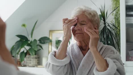 Ältere-Frau-Kämpft-Morgens-Im-Badezimmer-Mit-Kopfschmerzen